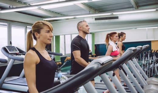 People Training Over Treadmills On Fitness Center