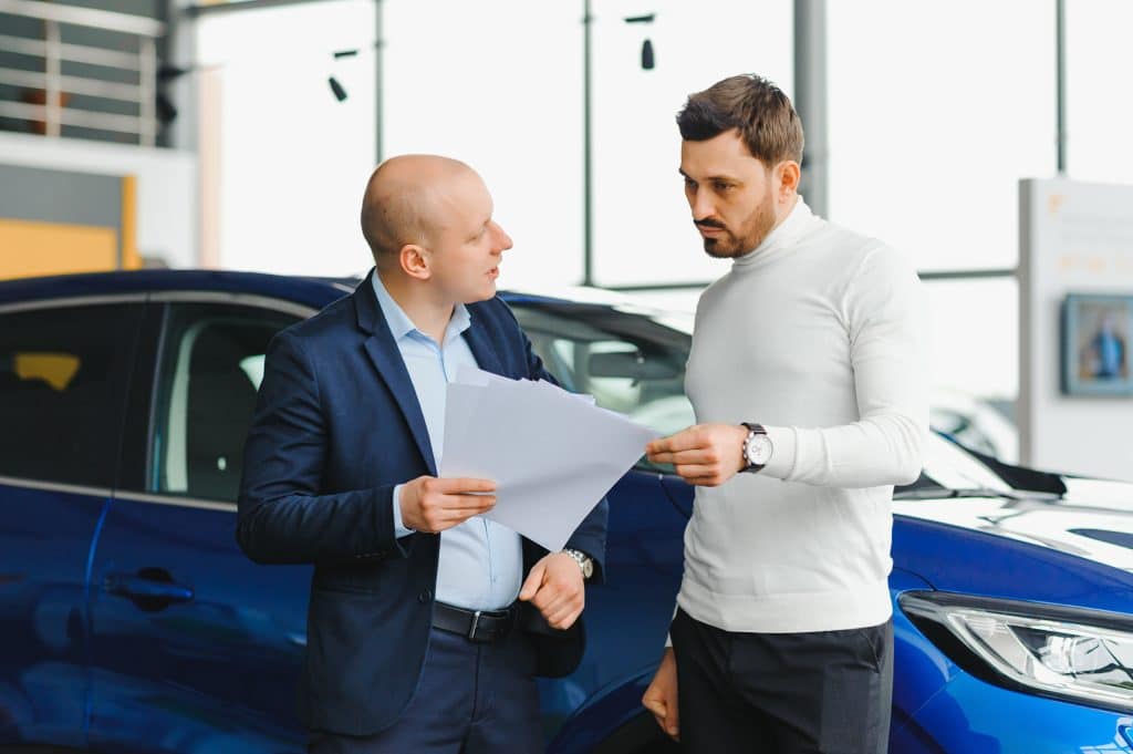 Salesperson Selling Cars At Car Dealership