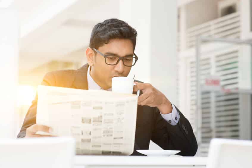 Business People Drinking Hot Coffee And Reading Newspaper At Caf