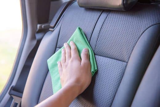 Hand Cleaning The Car Interior With Green Microfiber Cloth