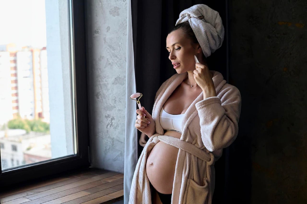 Une Belle Femme Enceinte En Peignoir Et Serviette Mak Faisant Une Soins De Visage.jpg