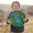 Little Boy Holding Planet In Hands Against Green Spring Background. Earth Day