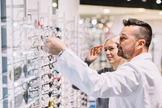 Optician And His Patient Choosing Glasses.