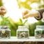 Businessman Hands Putting Money (coin) Into The Glass Jar