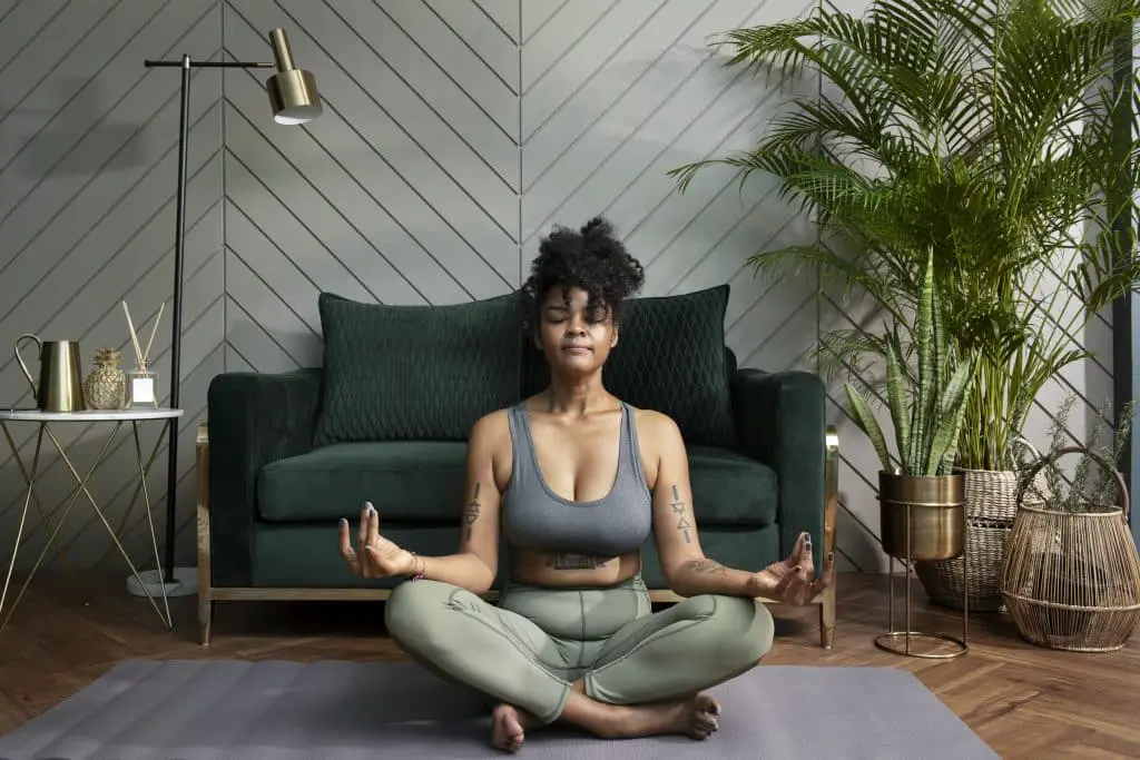 Healthy Woman Meditating In The Living Room