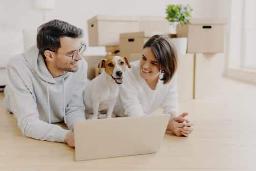 just married couple lie on floor, use laptop computer, creats design project for new house