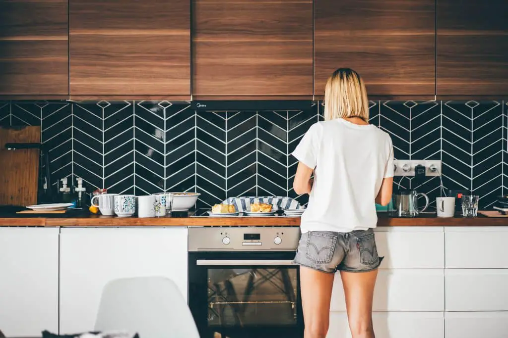 Young Woman Stands Near Modern Kitchen At Home.