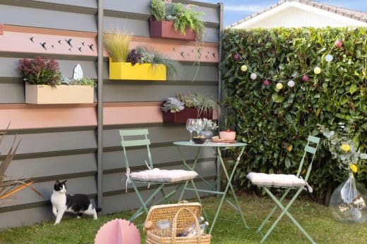 Un espace extérieur aménagé avec des meubles confortables, des plantes vertes et des éclairages d'ambiance.