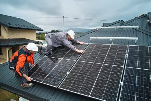 Des panneaux solaires installés sur le toit d'une maison avec un jardin en contrebas.