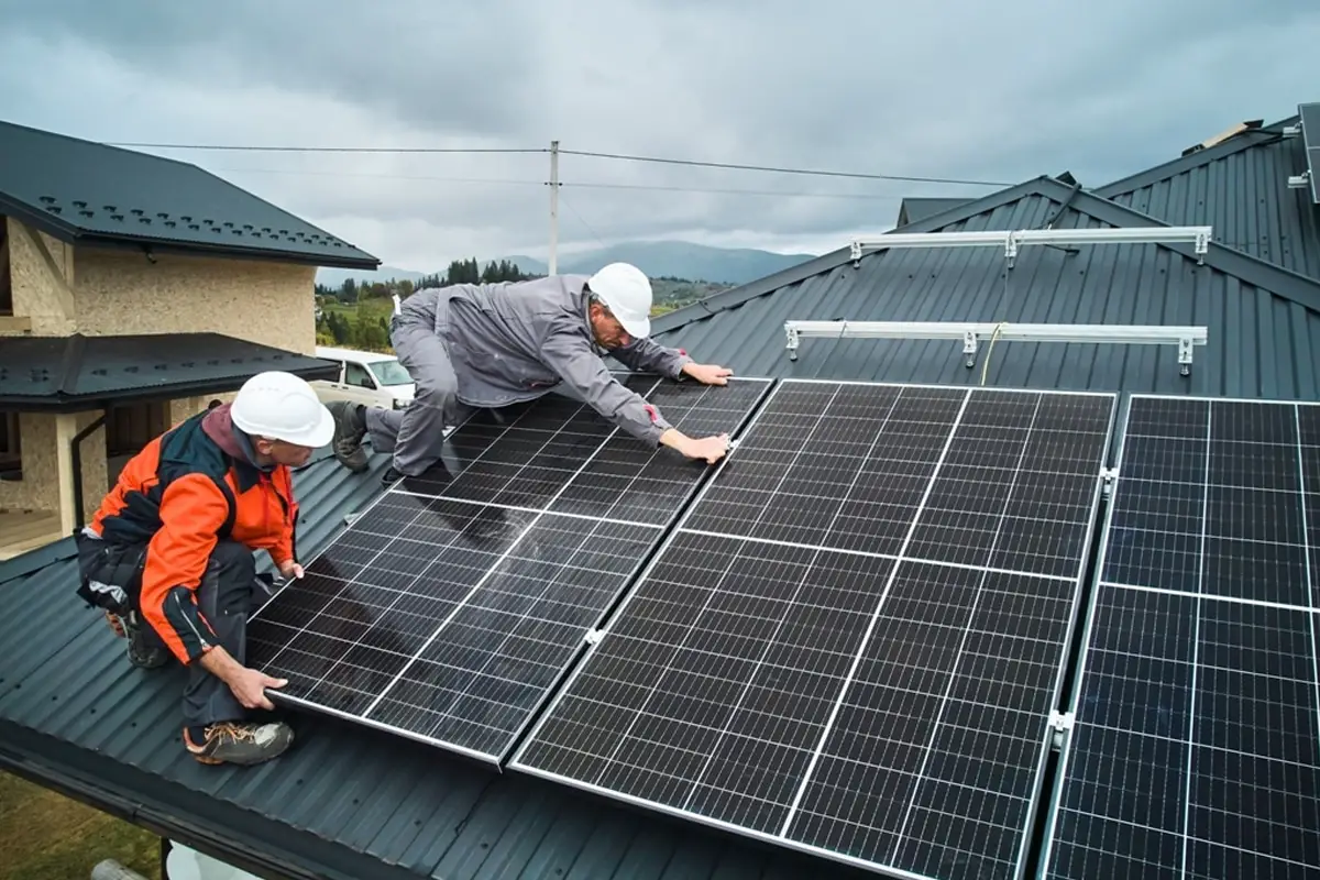 Des panneaux solaires installés sur le toit d'une maison avec un jardin en contrebas.