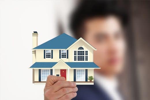 Agent immobilier tenant une petite maison en modèle.