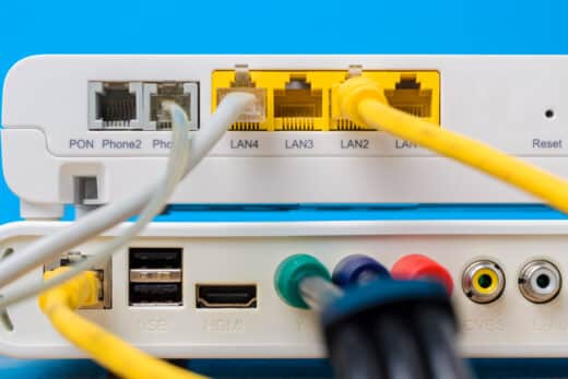 Home Wireless Router With Ethernet Cables Plugged In On Blue Bac