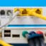 Home Wireless Router With Ethernet Cables Plugged In On Blue Bac