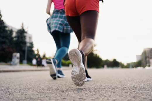 Two Multiethnic Girls Legs Running Through The City Streets, Outdoor Communicating.
