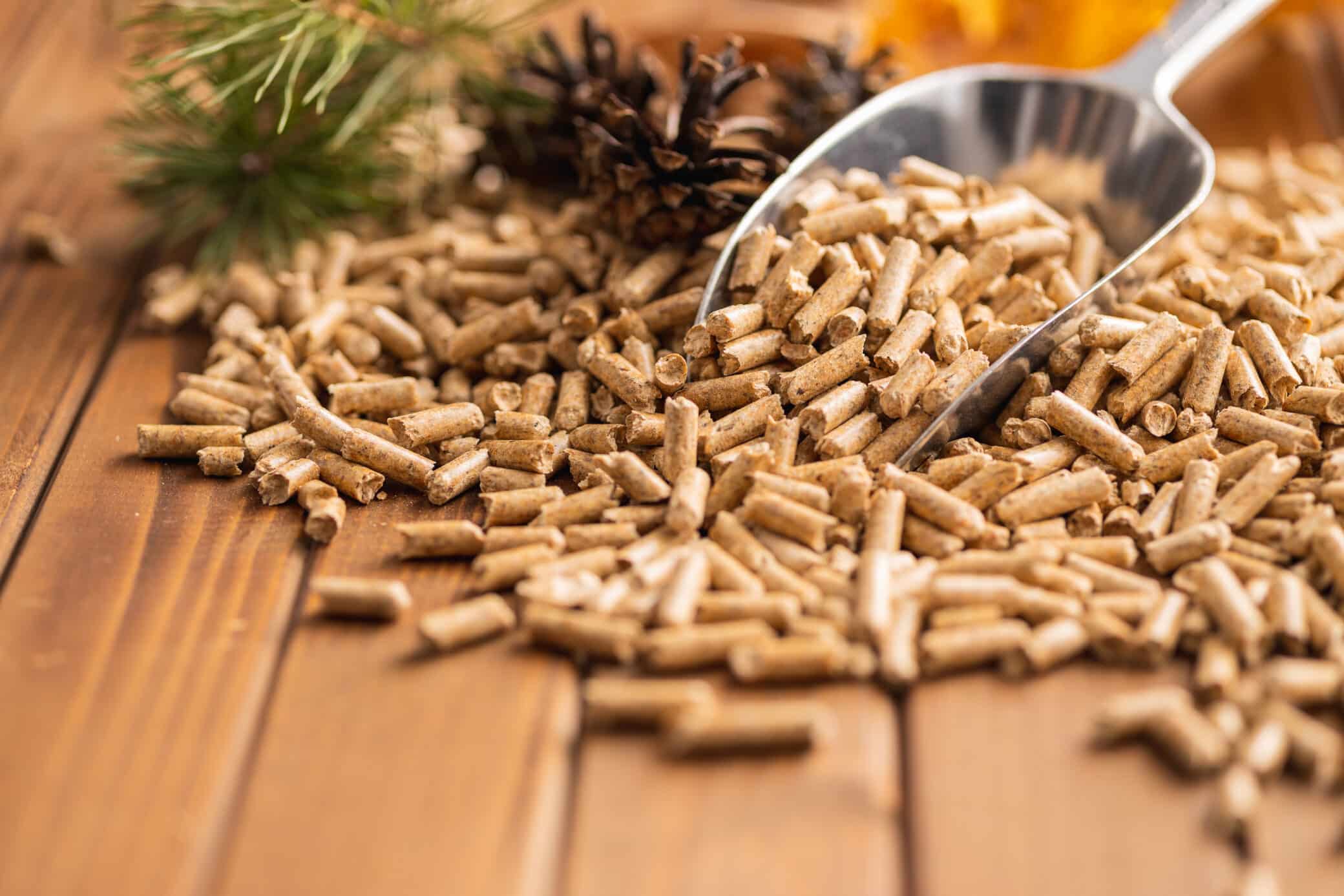 Wooden Pellets In Scoop On Wooden Table.